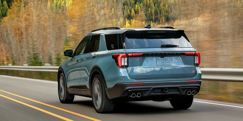 Blue 2026 Ford Explorer driving near wooded area on highway