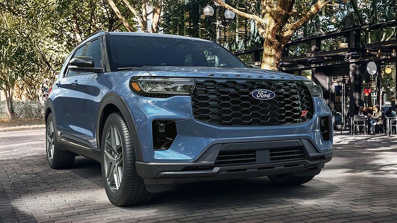 Green 2027 Ford Explorer driving through woods